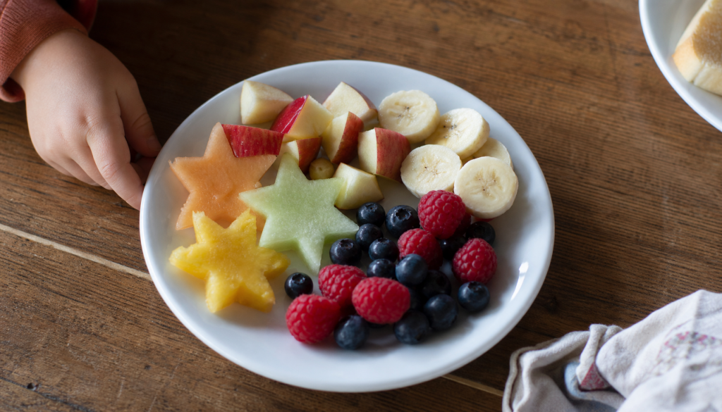 Kleine Obststücke in Farben und Formen auf einem Kinderteller als spielerische Obst-Safari